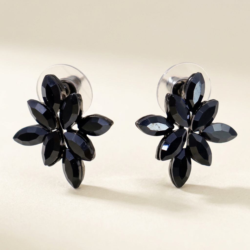 Orecchini a fiore con petali in vetro nero su sfondo avorio